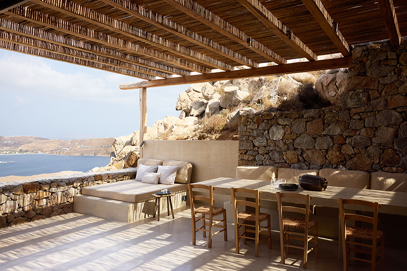 exposed stone masonry fuses restored residence by c-o lab with greek island's rocky terrain