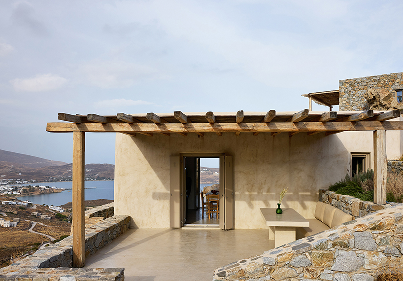 exposed stone masonry fuses restored residence by c-o lab with greek island's rocky terrain