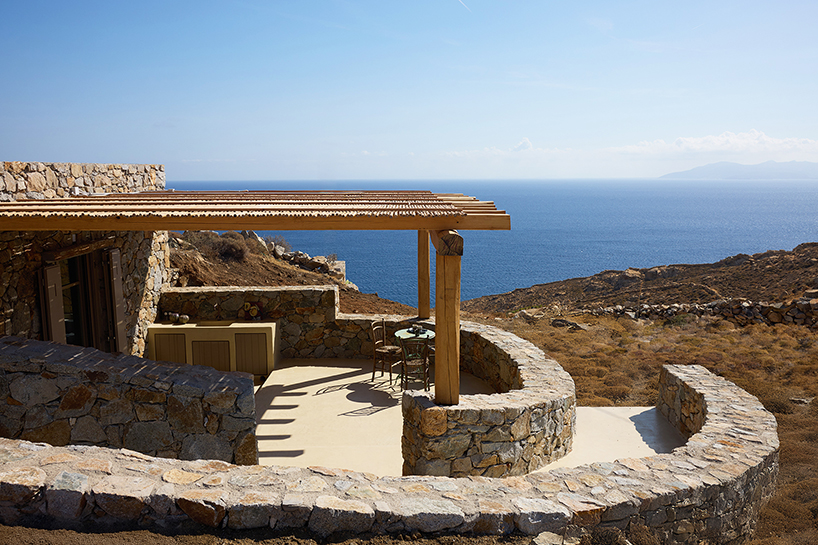 exposed stone masonry fuses restored residence by c-o lab with greek island's rocky terrain