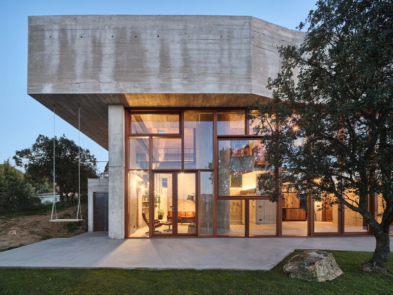 concrete-enveloped casa roble adapts to madrid's terrain with its continuous curved facade