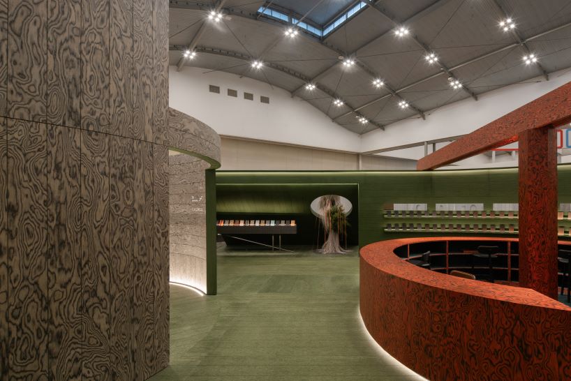 Pabellón circular de madera con huecos y huecos que muestra una variedad de texturas y acabados enchapados.