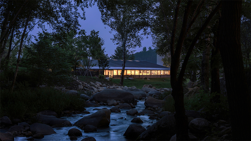 dark metal roof shapes community canteen beside mountain stream in china - 9