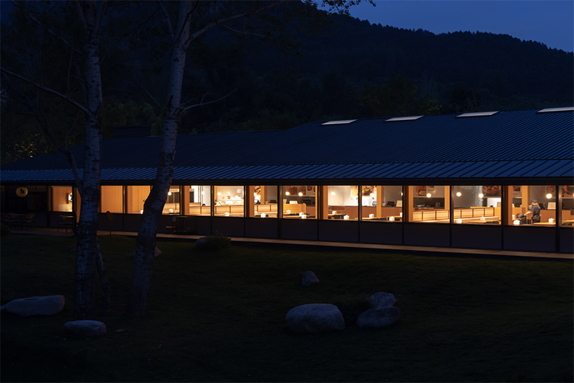 dark metal roof shapes community canteen beside mountain stream in china - 10
