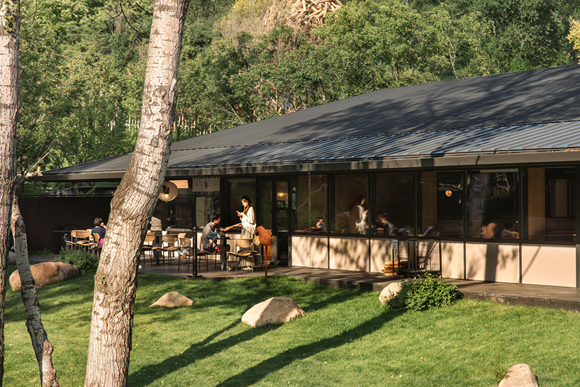 dark metal roof shapes community canteen beside mountain stream in china - 5