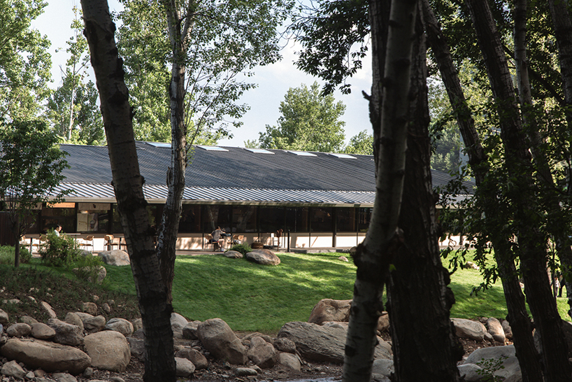 dark metal roof shapes community canteen beside mountain stream in china - 3