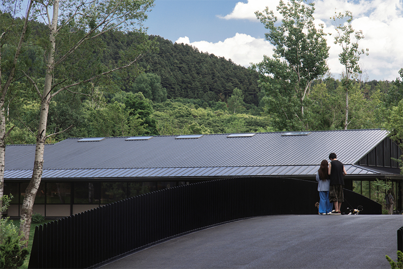 dark metal roof shapes community canteen beside mountain stream in china - 6