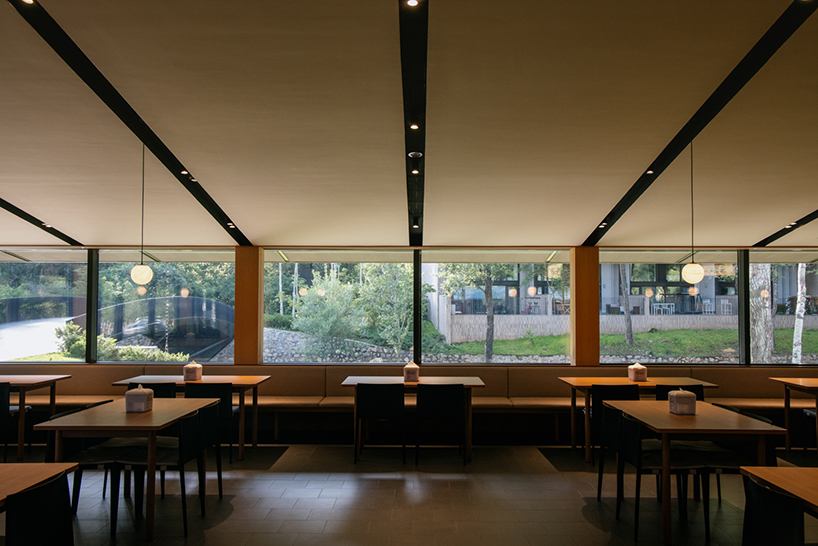 dark metal roof shapes community canteen beside mountain stream in china - 7