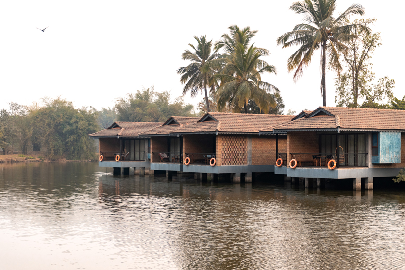 pond houses crafted from earth blocks float above land and water in india