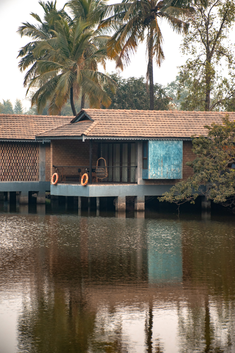 pond houses crafted from earth blocks float above land and water in india