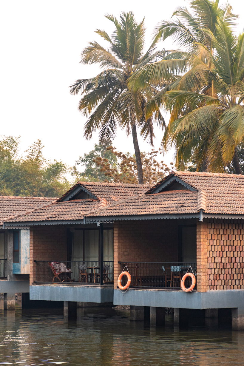 pond houses crafted from earth blocks float above land and water in india