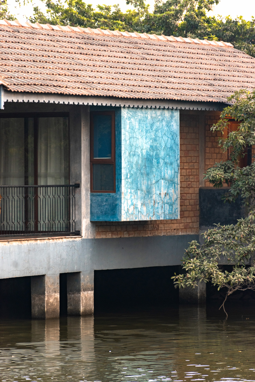 pond houses crafted from earth blocks float above land and water in india