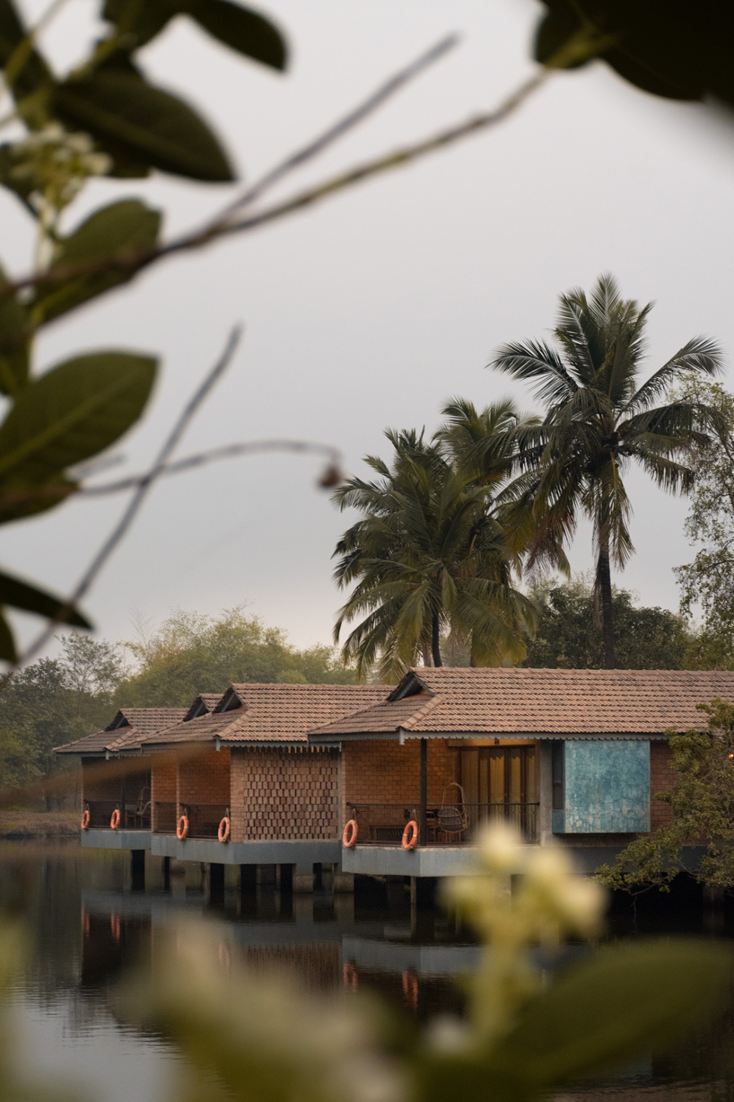 pond houses crafted from earth blocks float above land and water in india