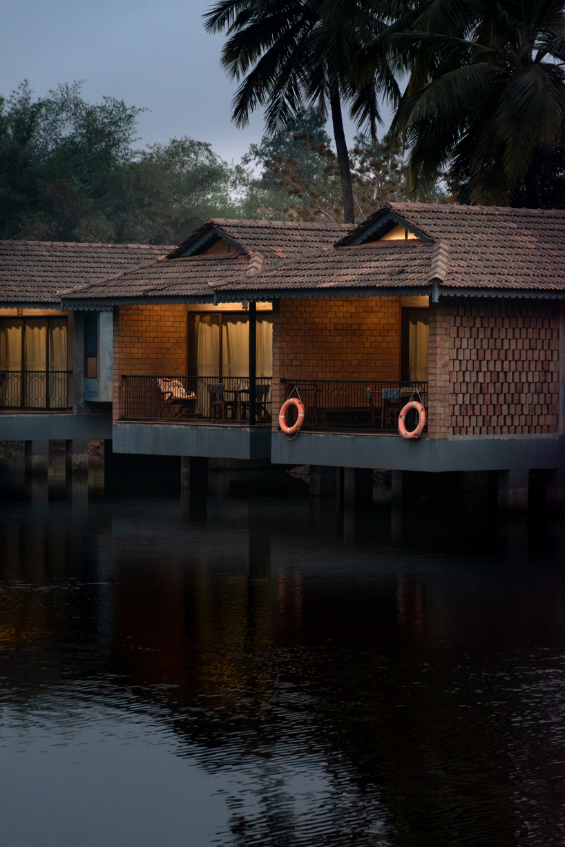 pond houses crafted from earth blocks float above land and water in india