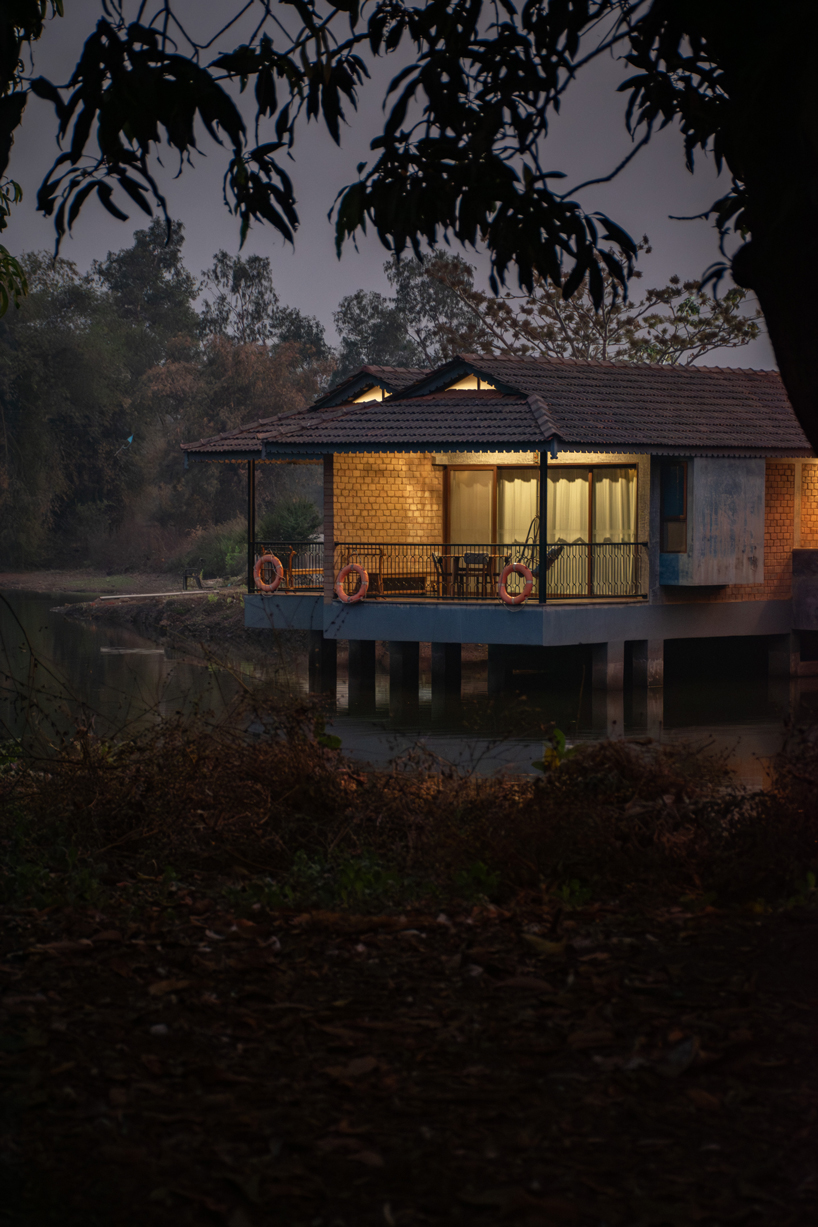 pond houses crafted from earth blocks float above land and water in india