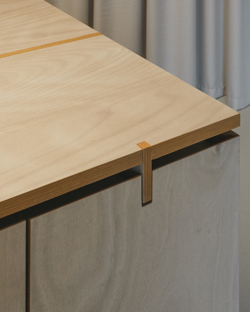 modular wooden table reforms into exhibition platform within ceramic workshop by AACM