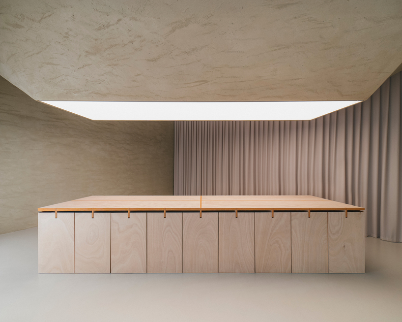 modular wooden table reforms into exhibition platform within ceramic workshop by AACM