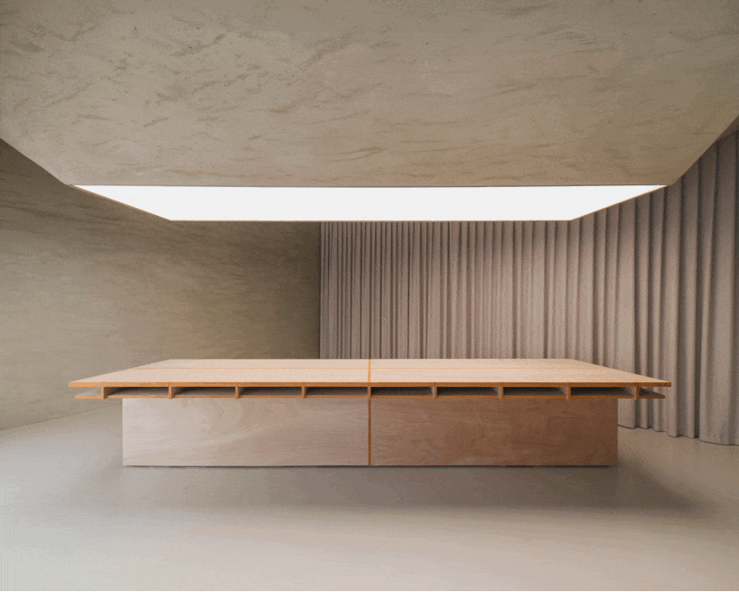 modular wooden table reforms into exhibition platform within ceramic workshop by AACM