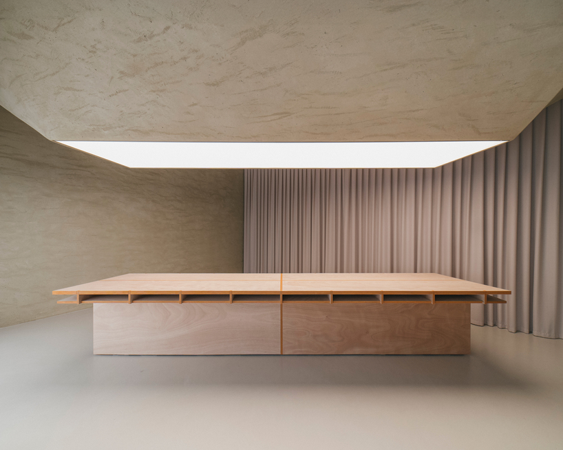 modular wooden table reforms into exhibition platform within ceramic workshop by AACM