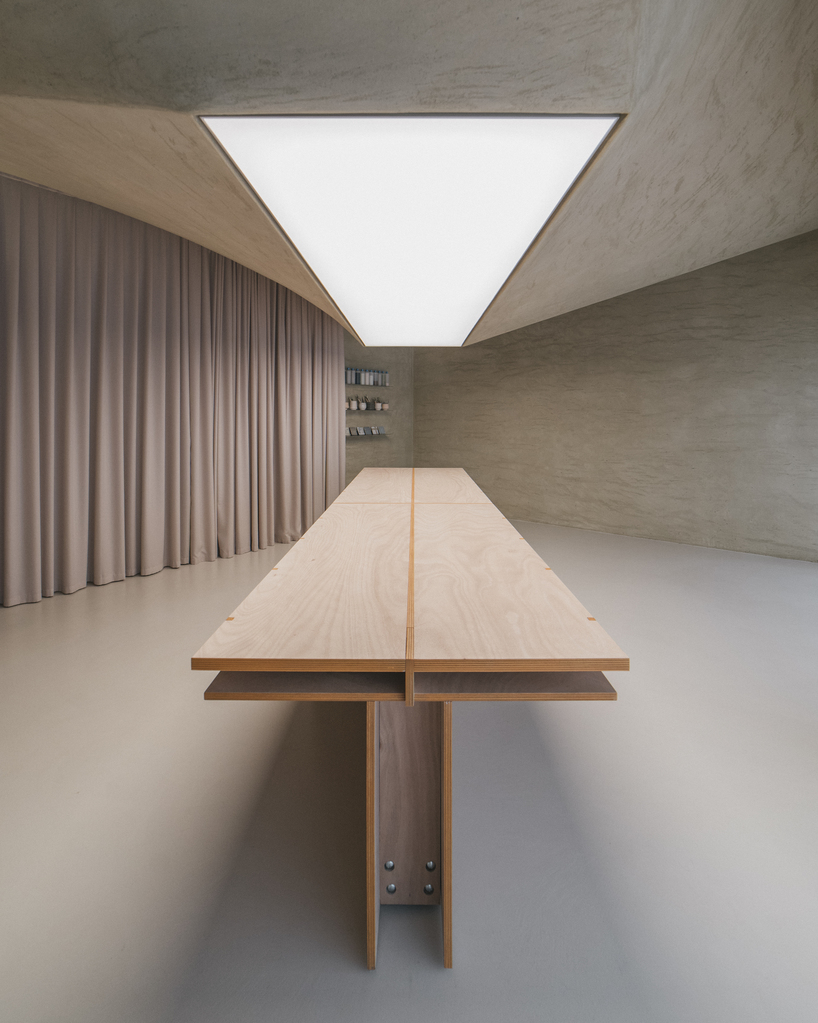modular wooden table reforms into exhibition platform within ceramic workshop by AACM
