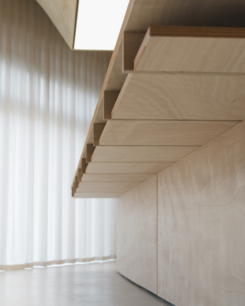 modular wooden table reforms into exhibition platform within ceramic workshop by AACM