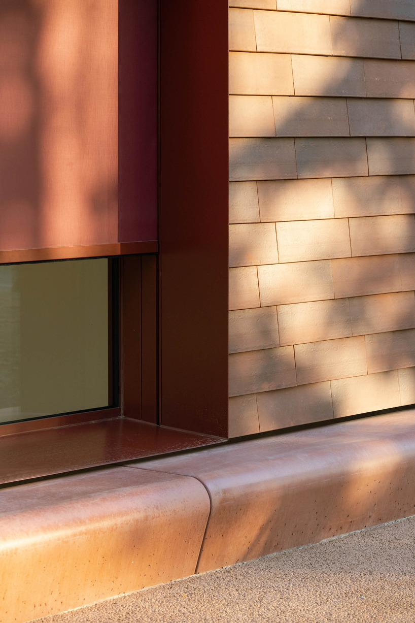 a cluster of terracotta-tiled pyramidal houses envelopes kindergarten in italy - 10