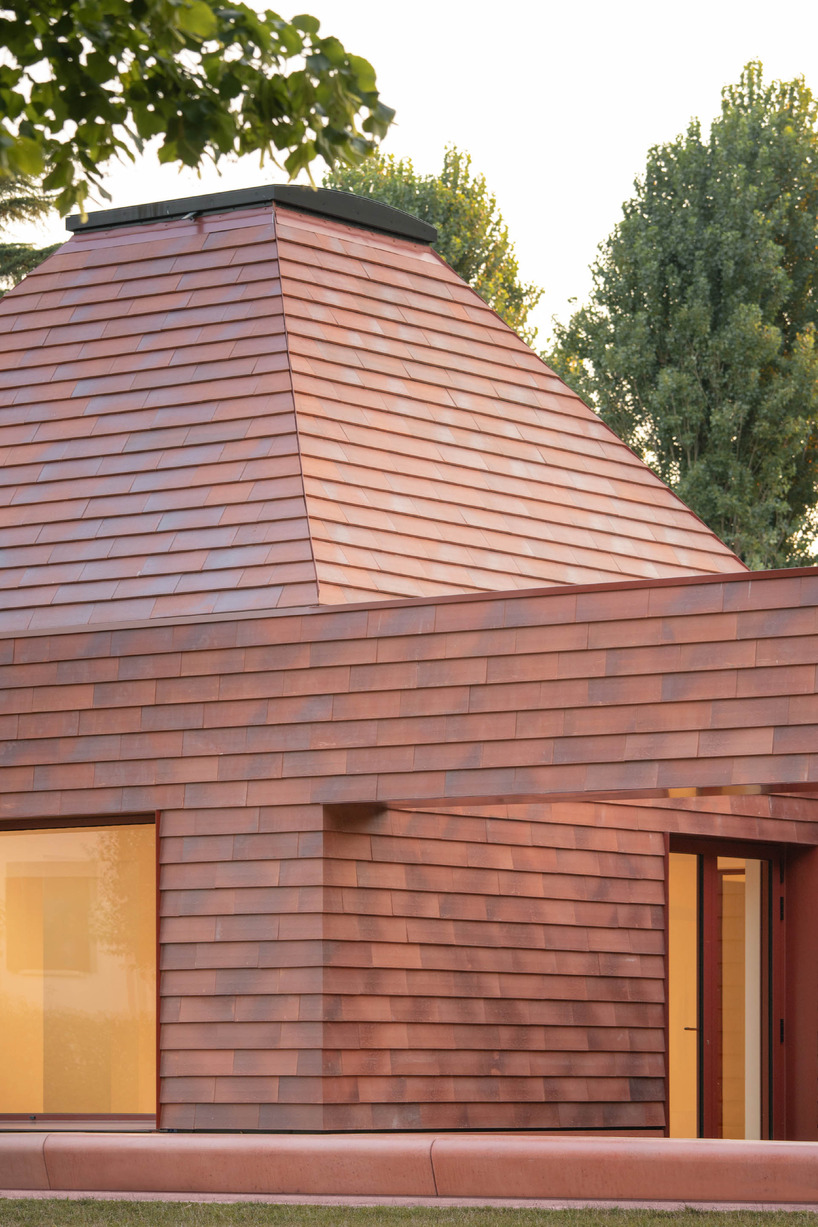 a cluster of terracotta-tiled pyramidal houses envelopes kindergarten in italy - 6