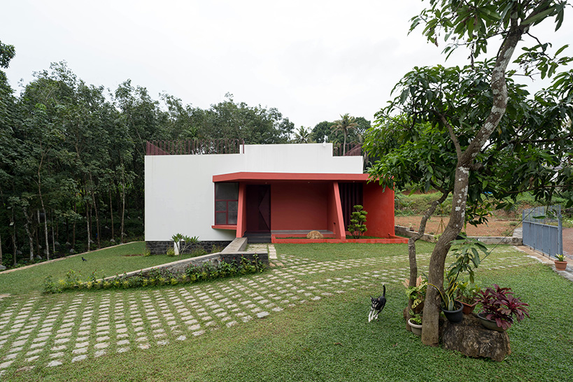 Geometric red wall segments come out of the white body of the Saba house in Indian Highlands