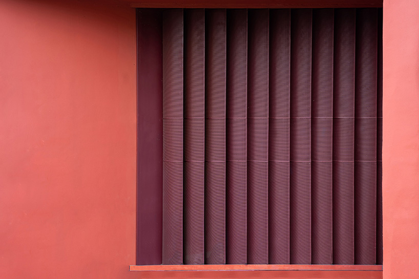 geometric red wall segments emerge from saba house's white body in indian highlands