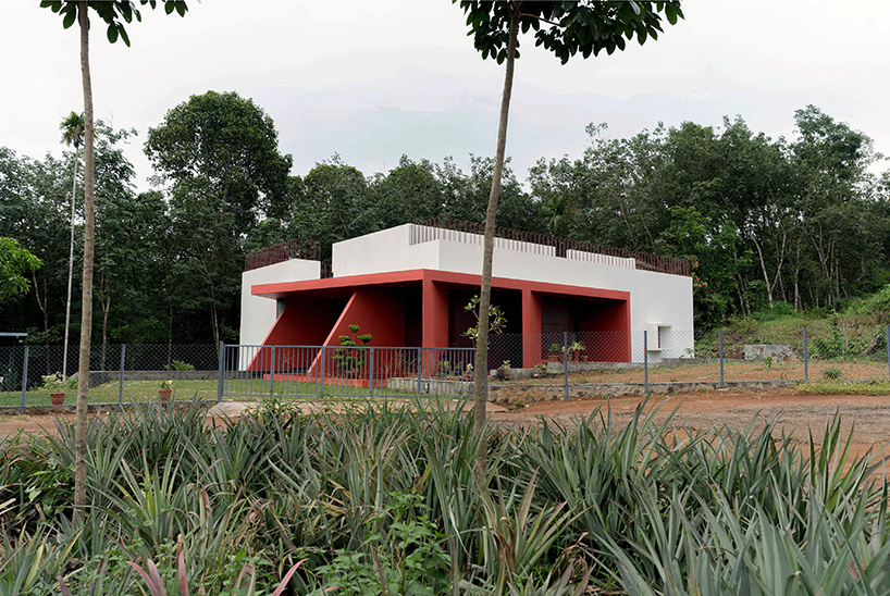Geometric red wall segments come out of the white body of the Saba house in Indian Highlands