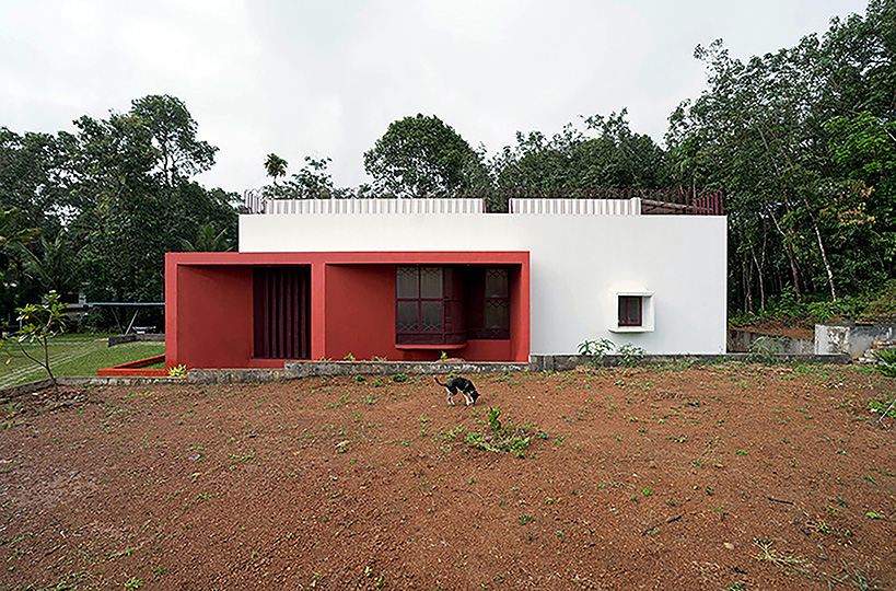 Geometric red wall segments come out of the white body of the Saba house in Indian Highlands