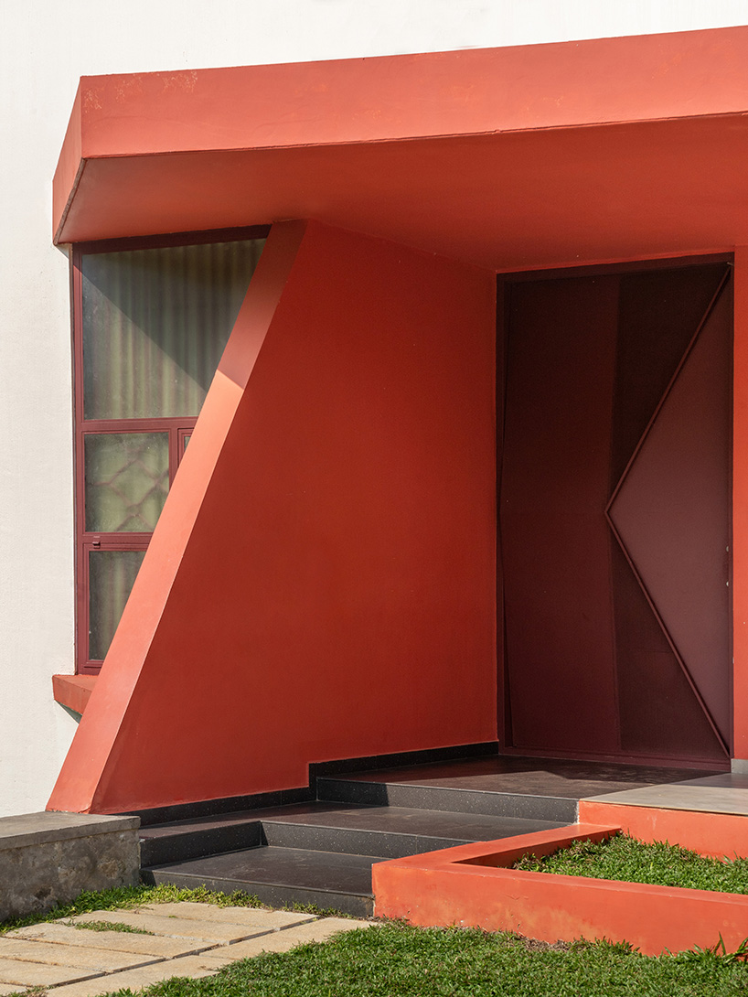 Geometric red wall segments come out of the white body of the Saba house in Indian Highlands