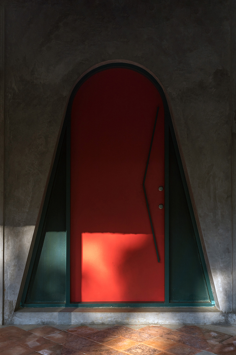 a semi-circular porous brick house stands amid rubber plantation in india