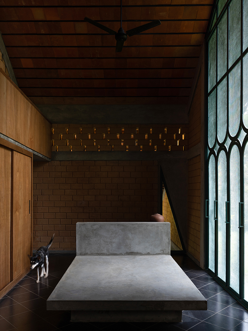 a semi-circular porous brick house stands amid rubber plantation in india