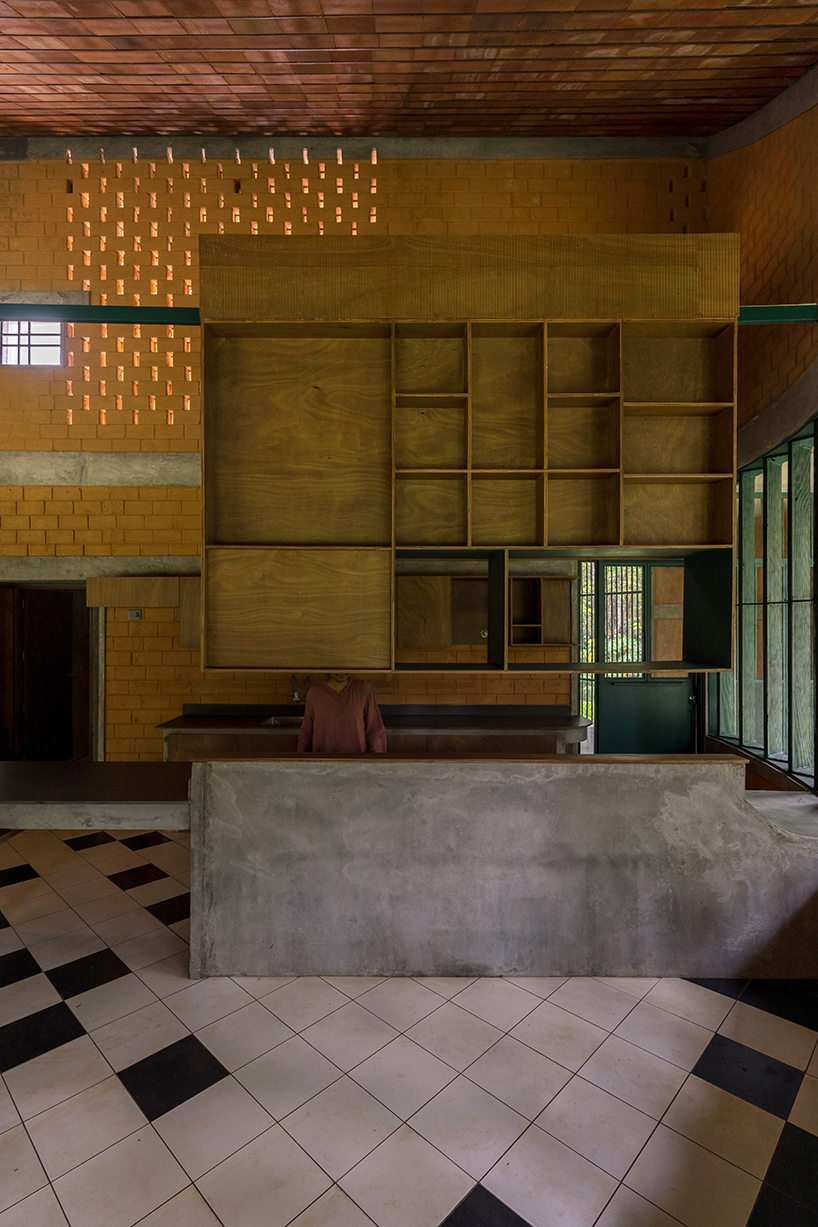 a semi-circular porous brick house stands amid rubber plantation in india