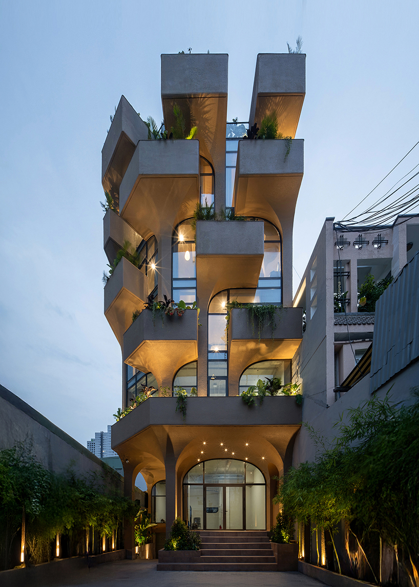 mixed-use unit's curved and vaulted volumes by room+ shape vertical garden in vietnam