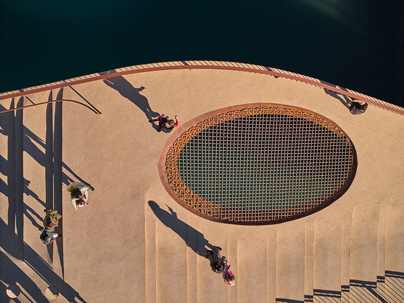 slender steel bridge with integrated net seating expands over foša port in croatia