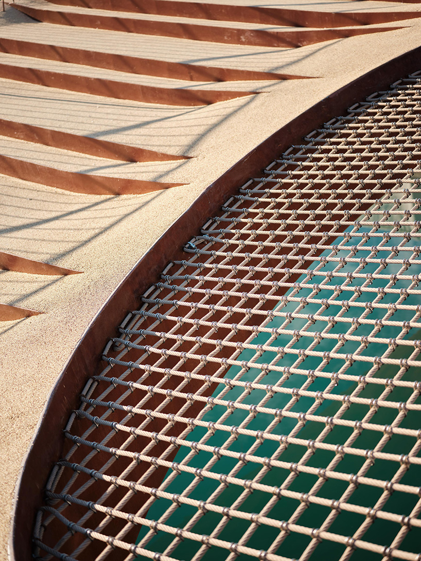 slender steel bridge with integrated net seating expands over foša port in croatia