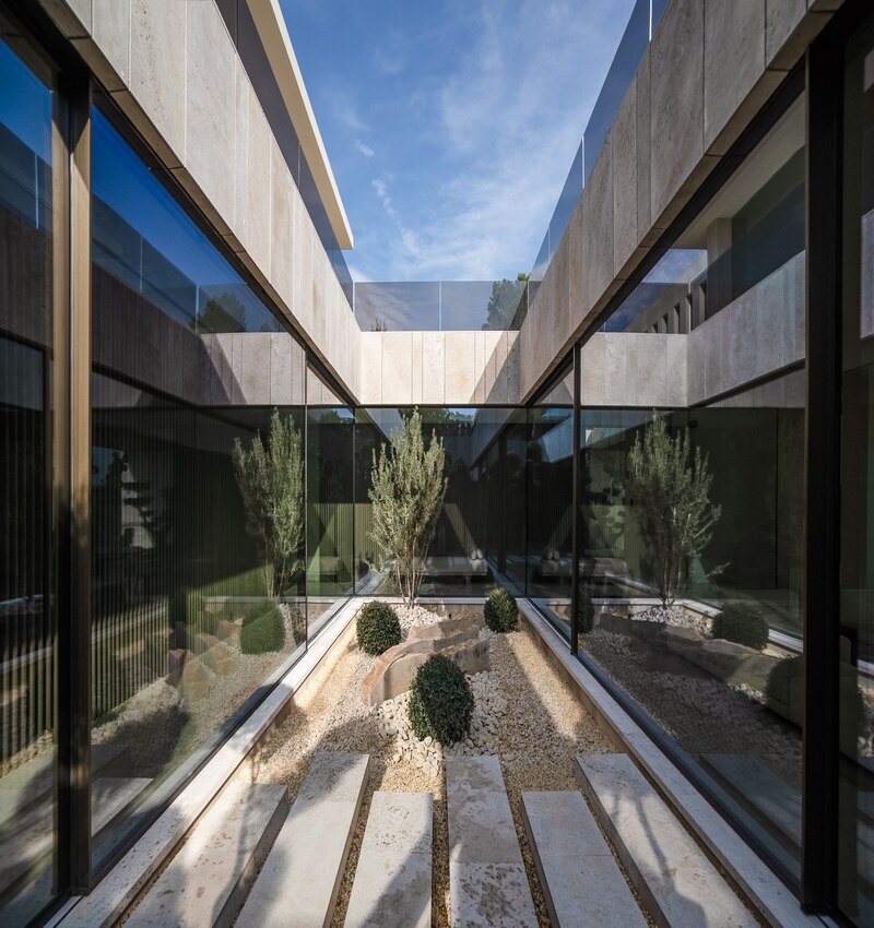 ARK architects elevates villa tai on stone podium framing views of mediterranean sea