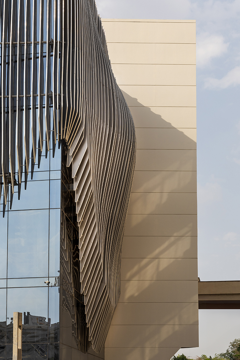 undulating aluminum curtain facade drapes over ain shams university theater in egypt