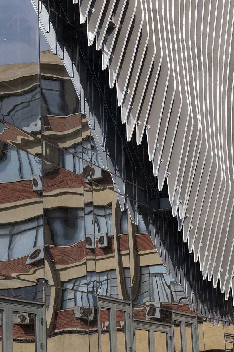 undulating aluminum curtain facade drapes over ain shams university theater in egypt