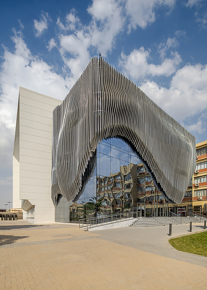 undulating aluminum curtain facade drapes over ain shams university theater in egypt