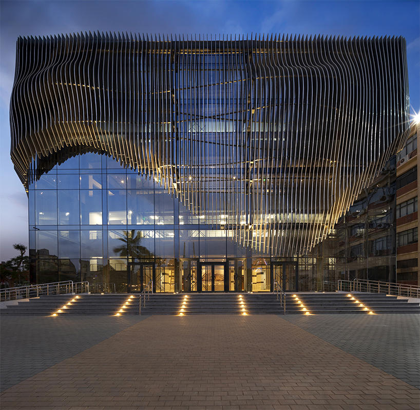 undulating aluminum curtain facade drapes over ain shams university theater in egypt