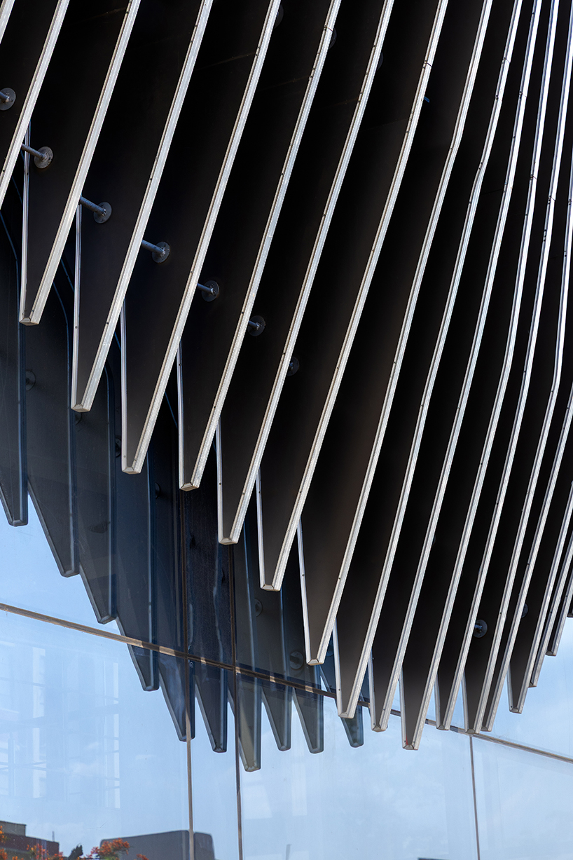 undulating aluminum curtain facade drapes over ain shams university theater in egypt