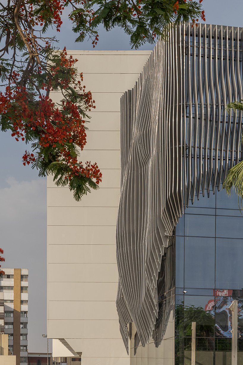 undulating aluminum curtain facade drapes over ain shams university theater in egypt