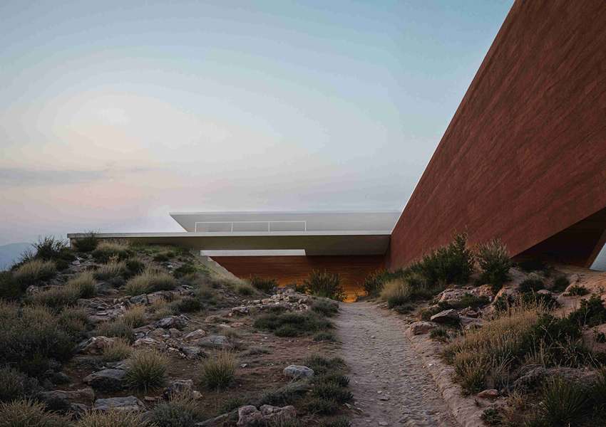 summer residence's sharp geometry emerges from greek seaside slope