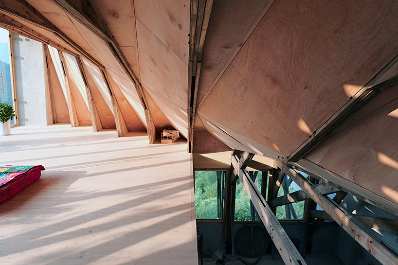 transforming roofscape expands over timber farmhouse in yunnan, china