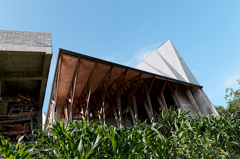transforming roofscape expands over timber farmhouse in yunnan, china