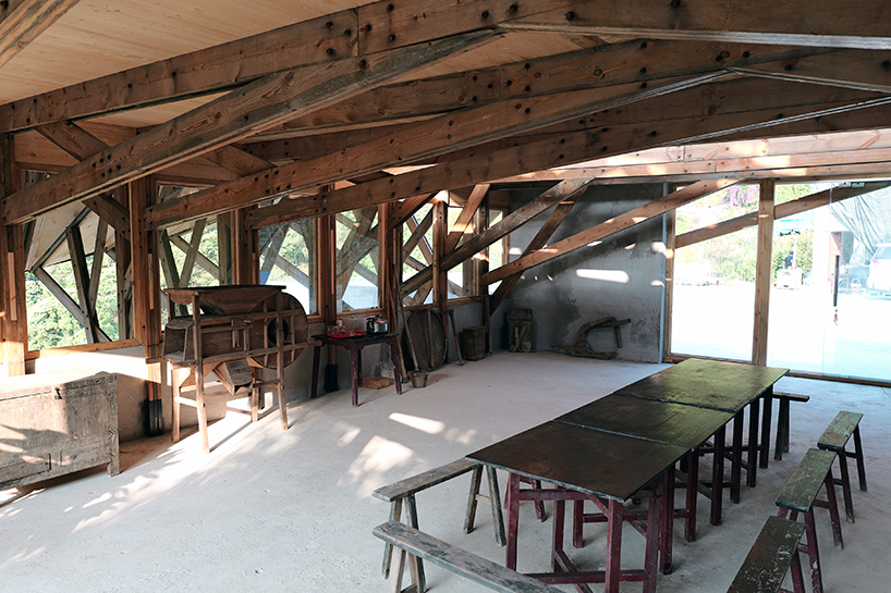 transforming roofscape expands over timber farmhouse in yunnan, china