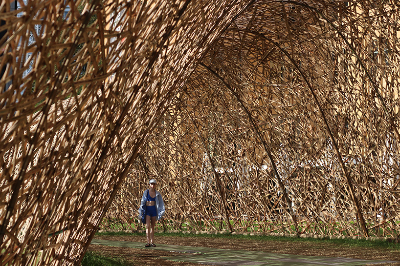 thousands of hand-split bamboo strands weave curved tunnel by cave urban in sydney
