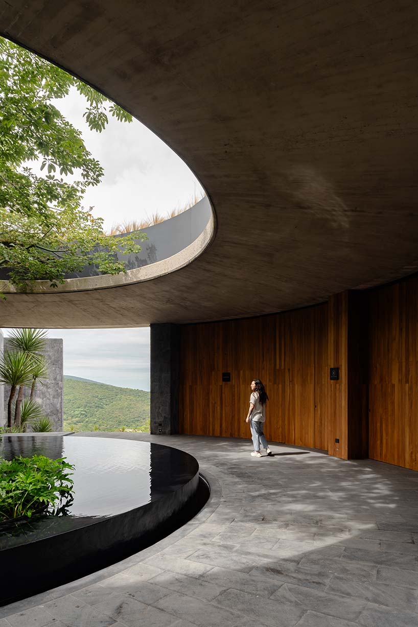 curved stone pavilion encloses circular reflecting pool for clubhouse in mexico